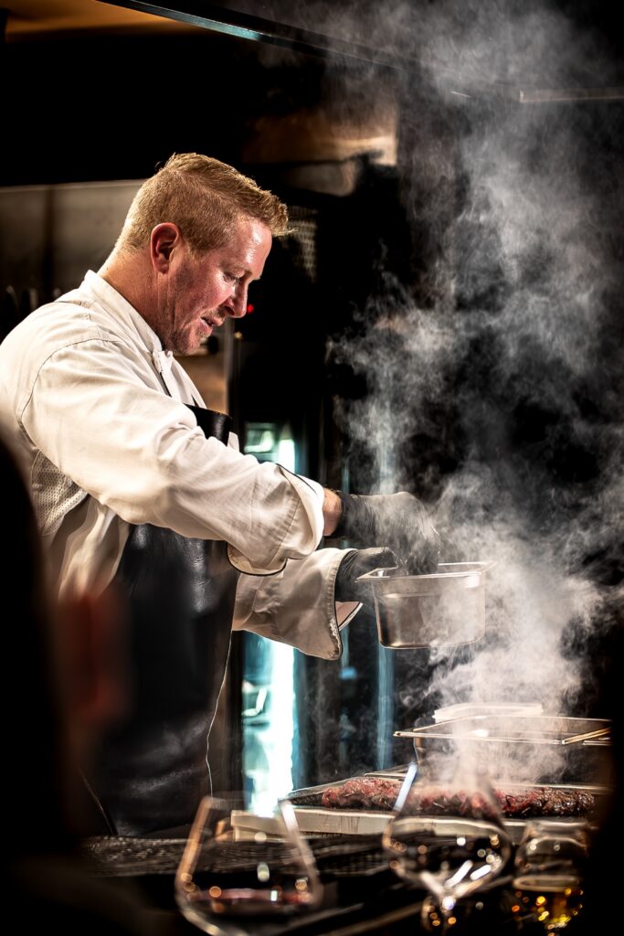 Chef plating Mayura Full-Blood Wagyu with rising steam