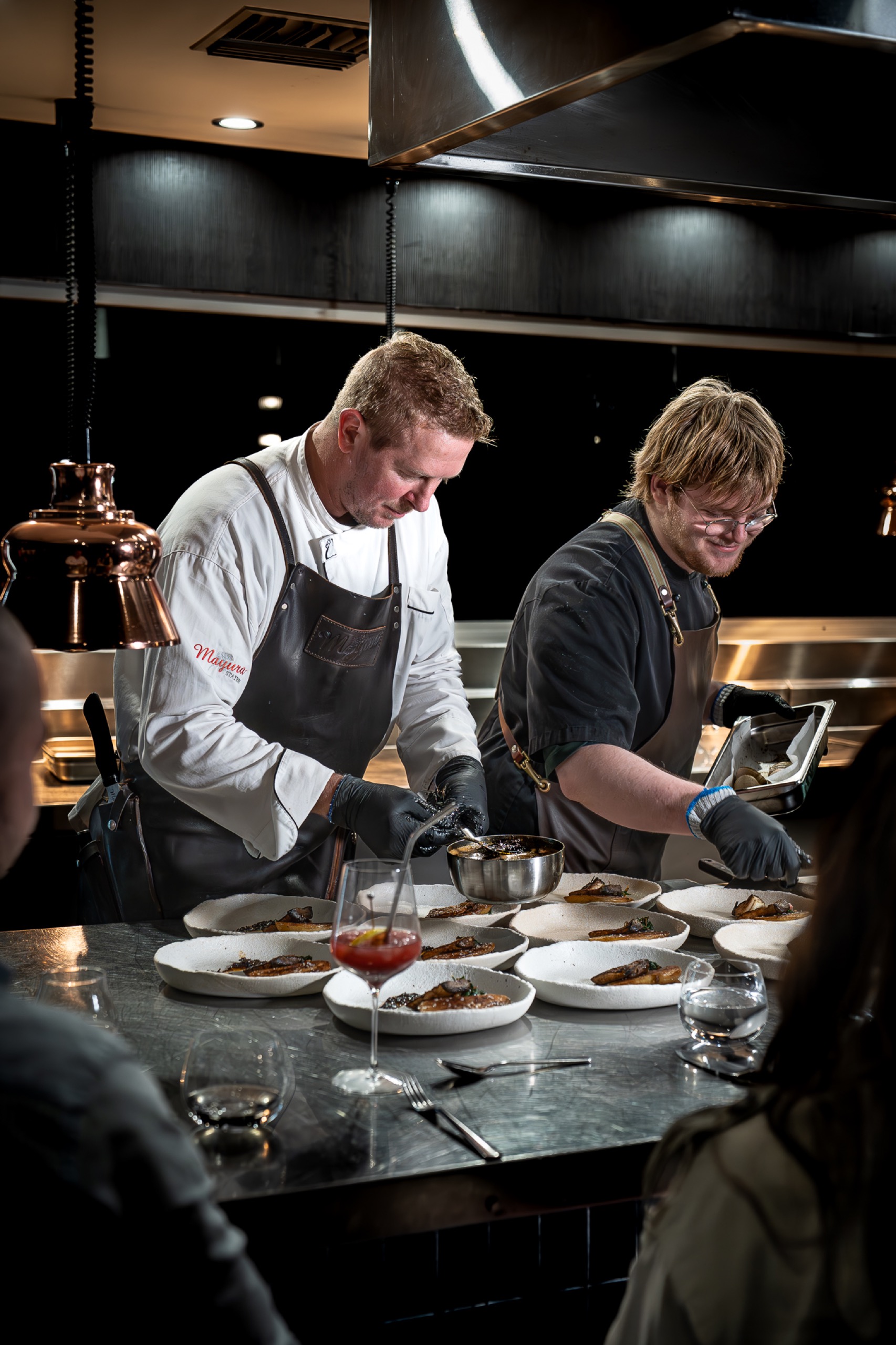 Two chefs plating Mayura Full-Blood Wagyu at the kitchen pass