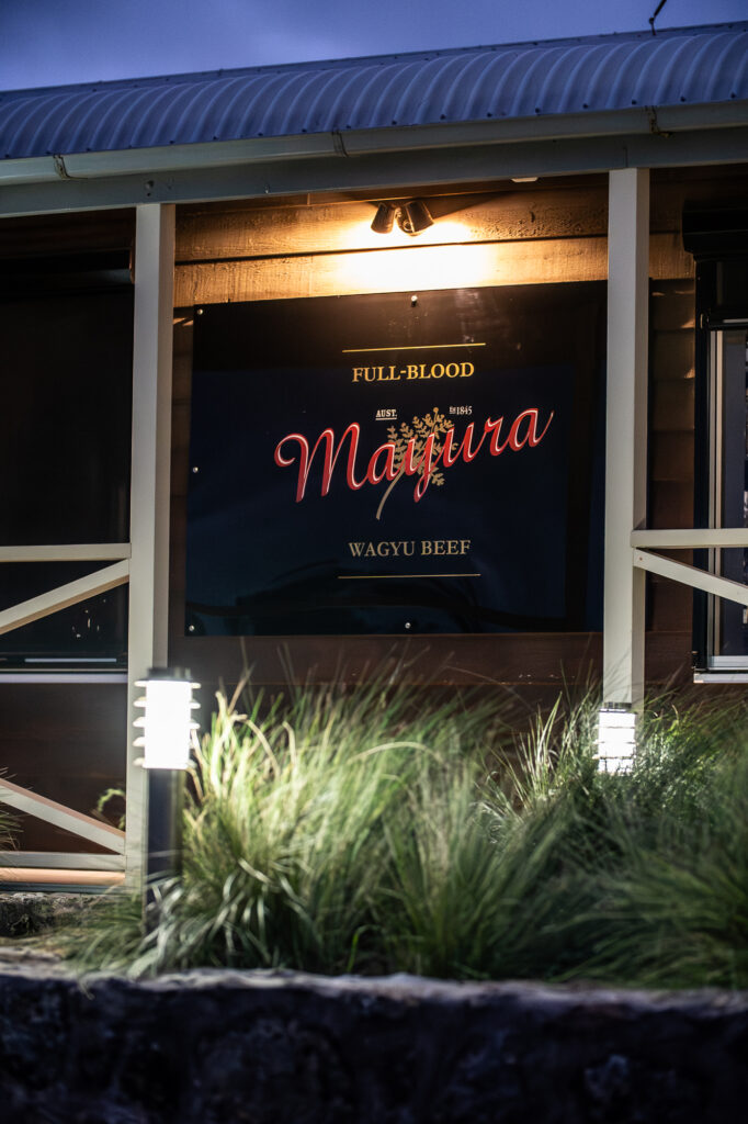 The Mayura Wagyu Steakhouse timber exterior with Full-Blood Mayura Wagyu signage, lit at dusk